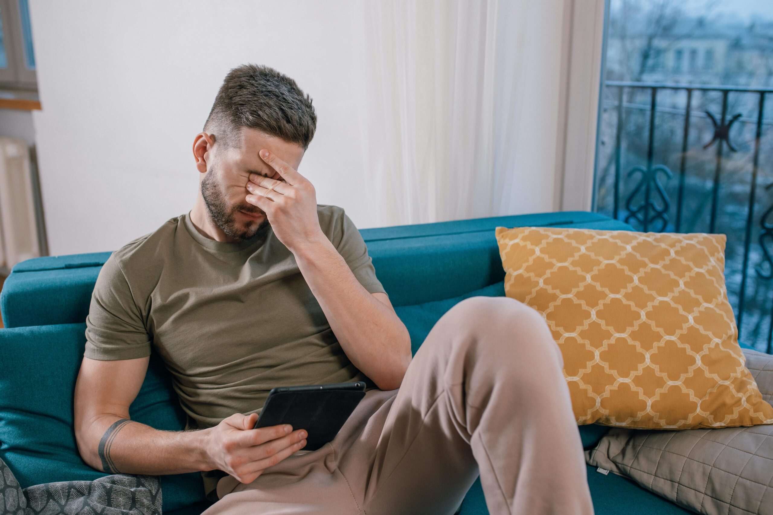 man frustrated while looking at ipad