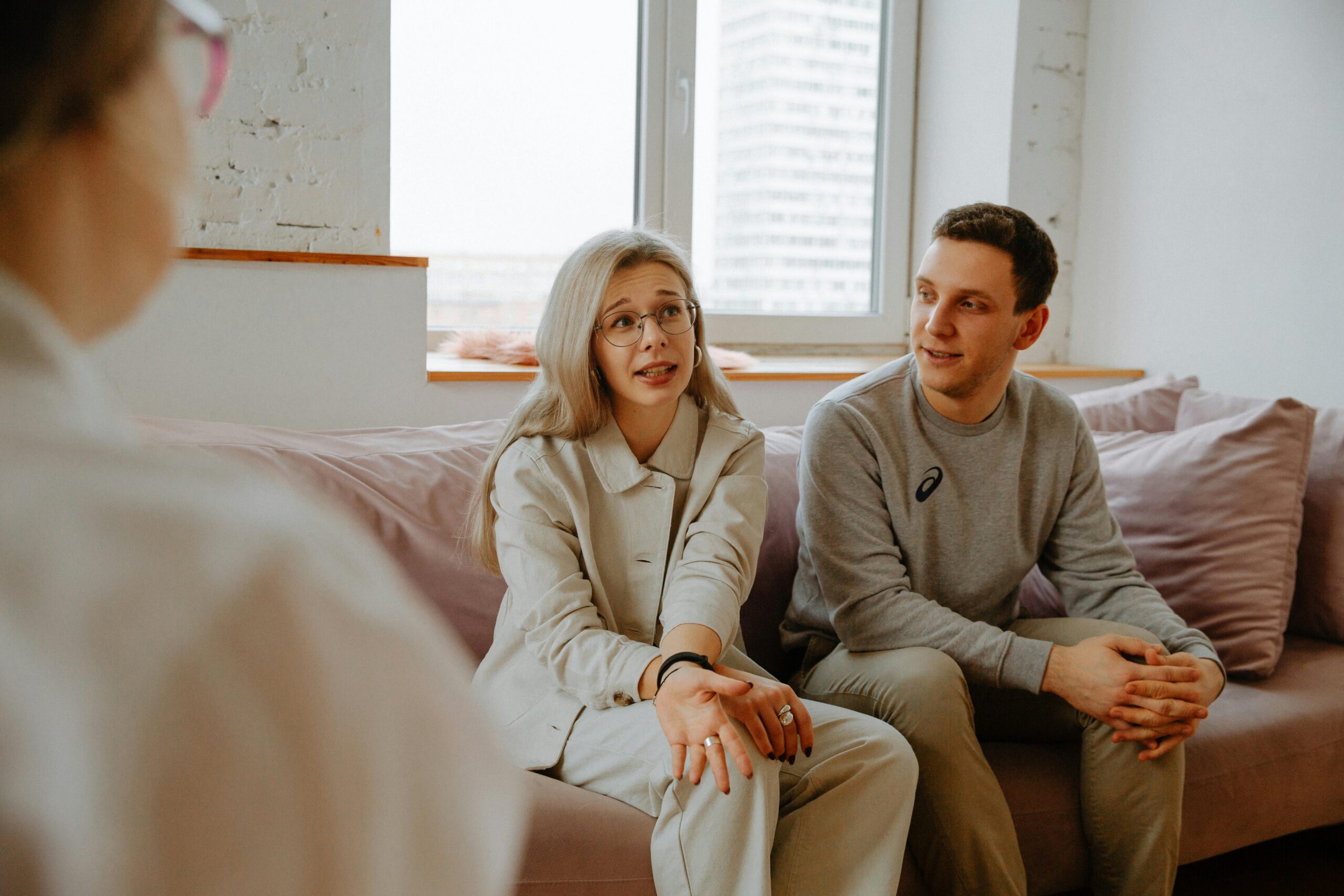 woman and man sitting on couch in relationship counselling session.